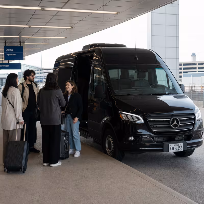 Group boarding a white charter bus for Airport Transportation transportation in Dallas