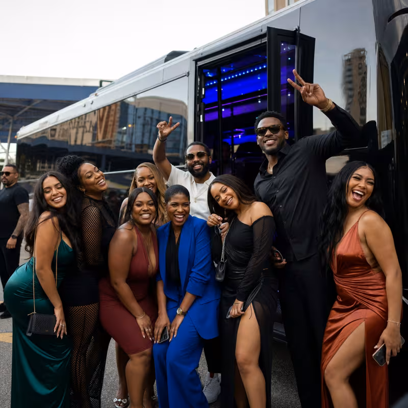 Group boarding a white charter bus for Birthday Transportation transportation in Dallas