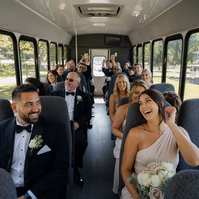 Group boarding a white charter bus for Wedding Transportation transportation in Dallas